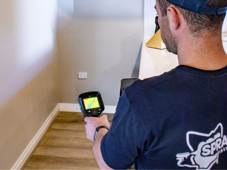 Man holding thermal imaging camera in kitchen