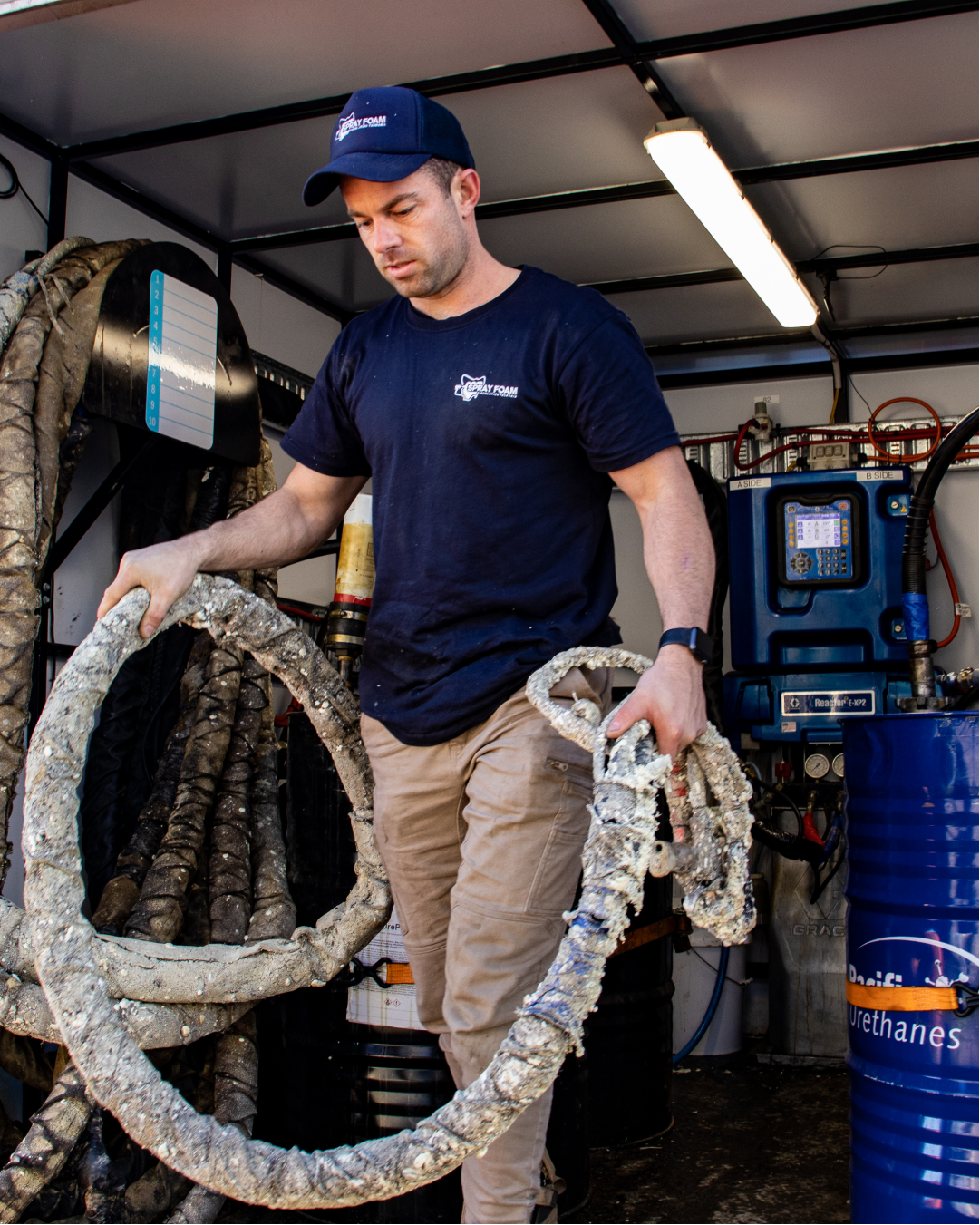 Man carrying spray foam hose